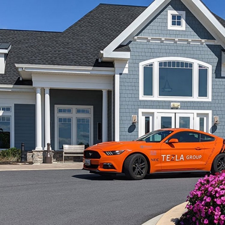 Tezla Group Orange Mustang in front of house